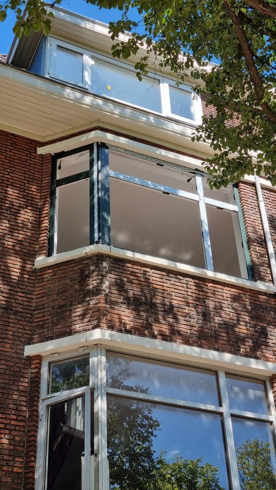 Erker met donkere kozijnen aan een bakstenen woning door Select Kozijnen