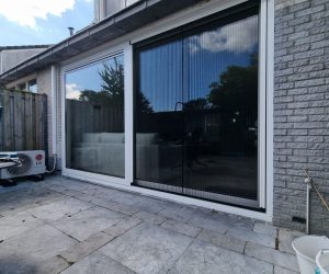 Grote schuifpui met donkere kozijnen aan moderne gevel door Select Kozijnen
