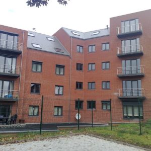 Appartementengebouw met rode gevel en moderne kozijnen door Select Kozijnen